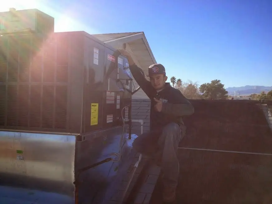 HVAC technician performing HVAC Inspection on a rooftop unit in Huntsville